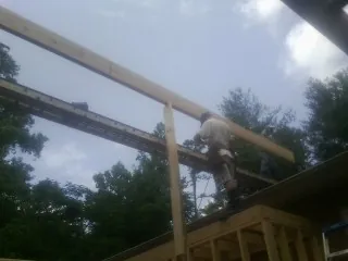 Carpenter setting a ridge beam over a new addition frame — Ice Dam Removal by Roofing Brothers in Lawson