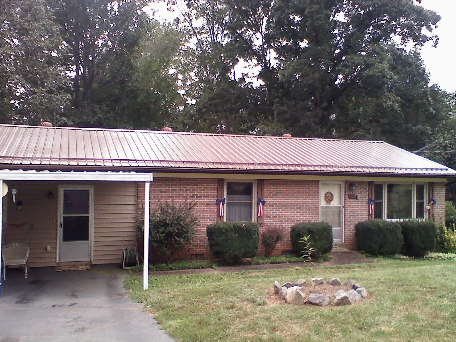 Bronze metal roof and carport on a brick ranch home — Roof Repair work by our crew in Lawson