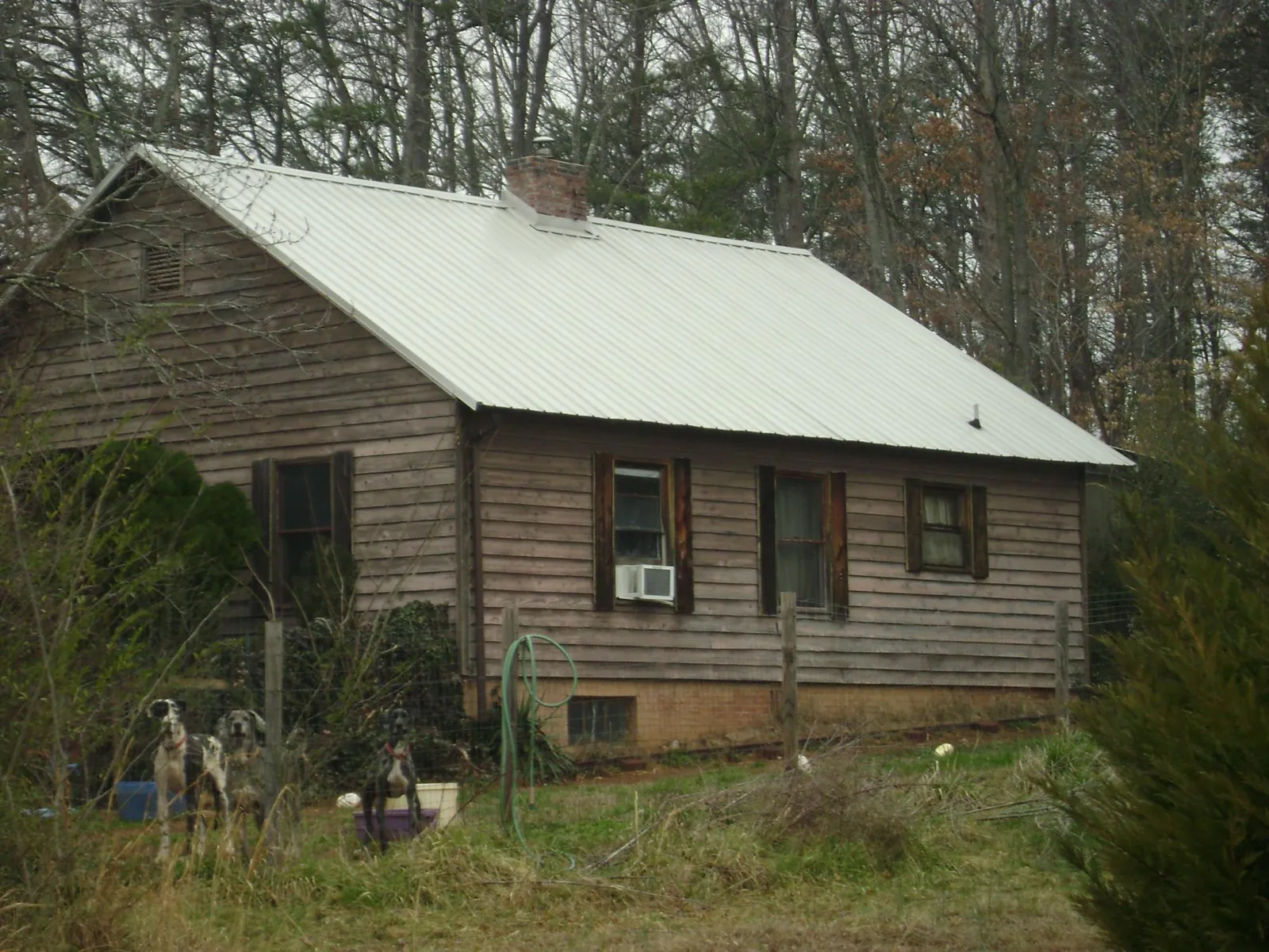 White metal roof on an old wood sided farmhouse, from a Metal Roof Installation job in Lawson